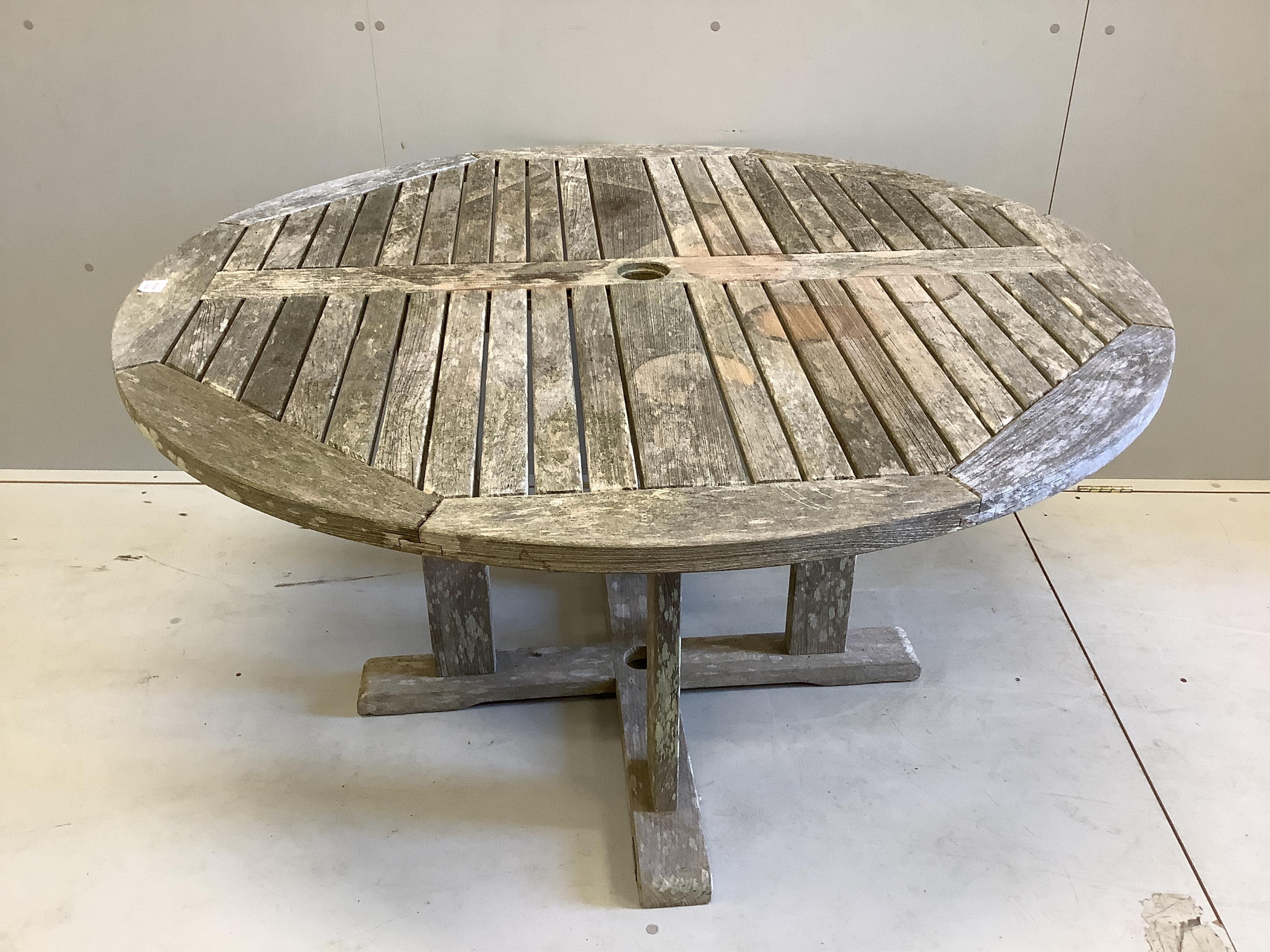 A Gloster circular weathered teak garden table, diameter 129cm, height 69cm. Condition - fair